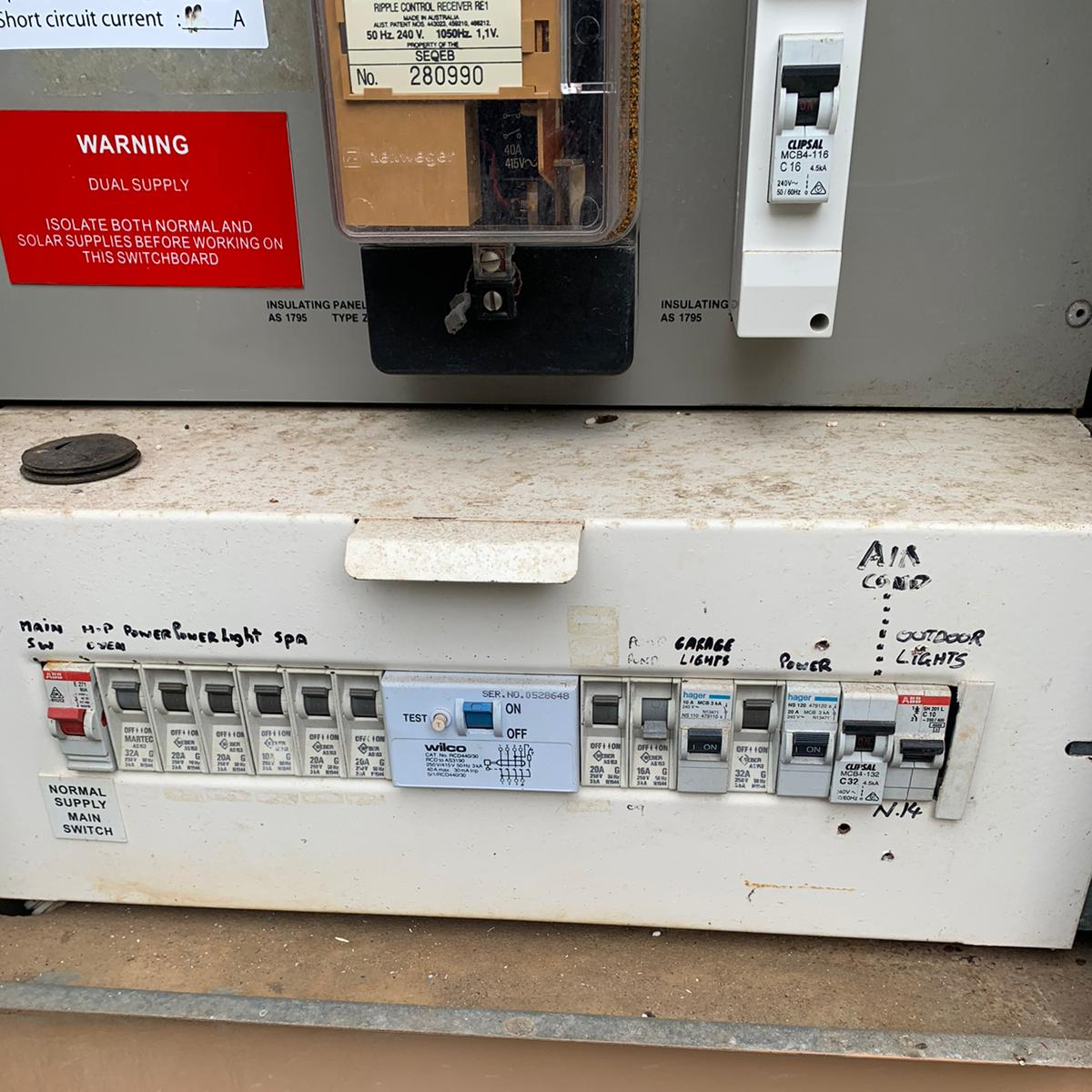 Old switchboard with hand-written labels before the upgrade