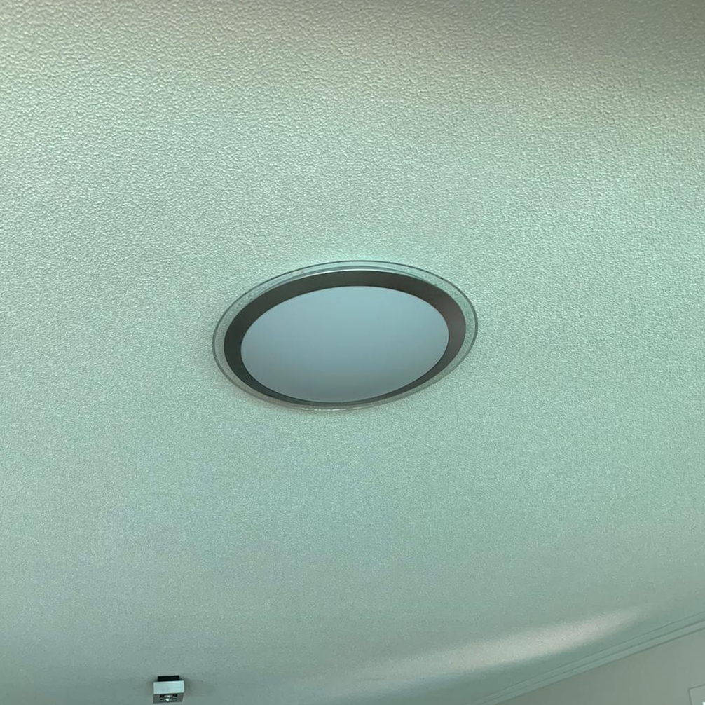 Round LED oyster light on a textured ceiling
