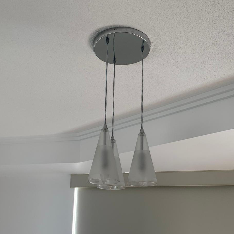 Three glass pendant lights over a renovated room